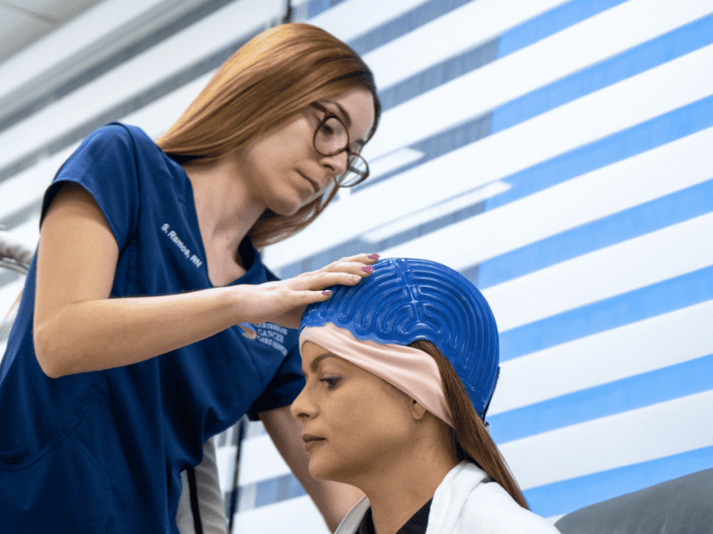 Nurse helping patient with Scalp Cooling System